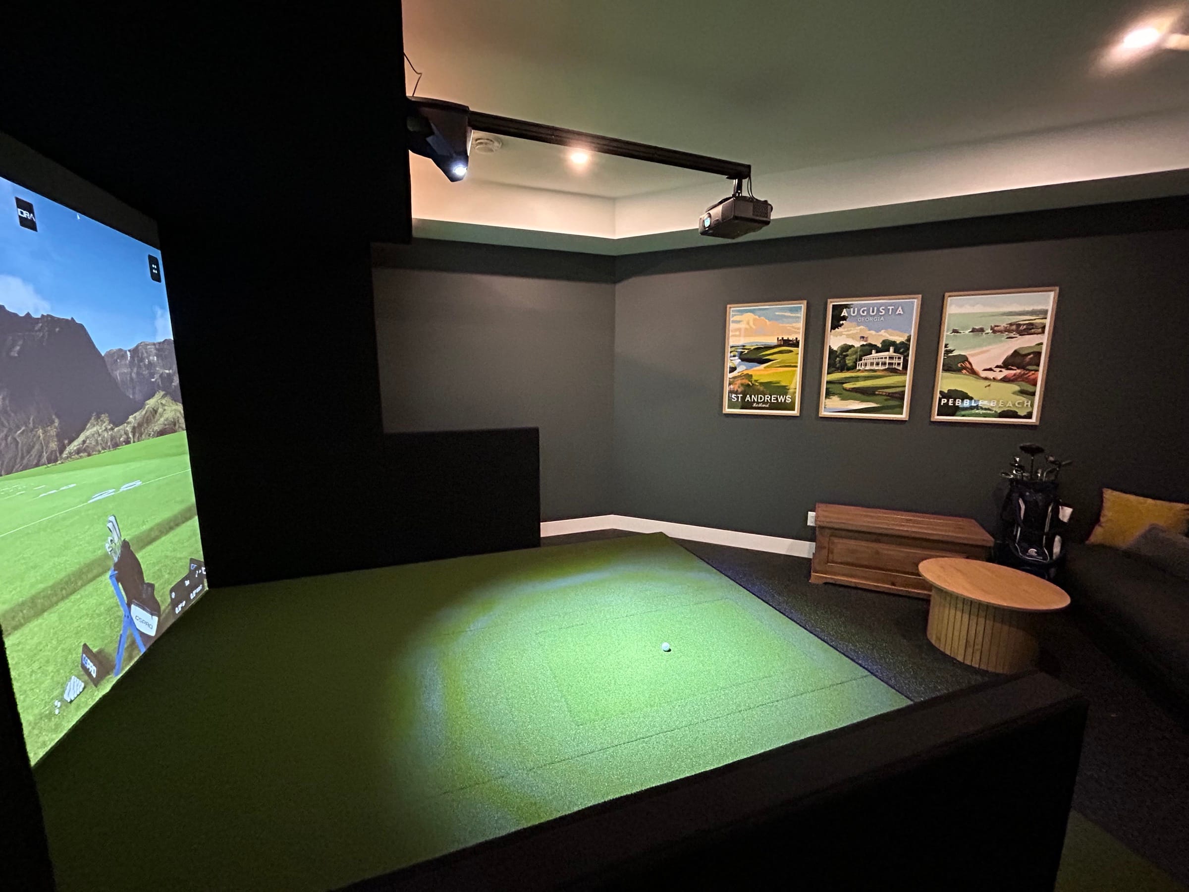 Premium lounge-style simulator room with course posters and seating