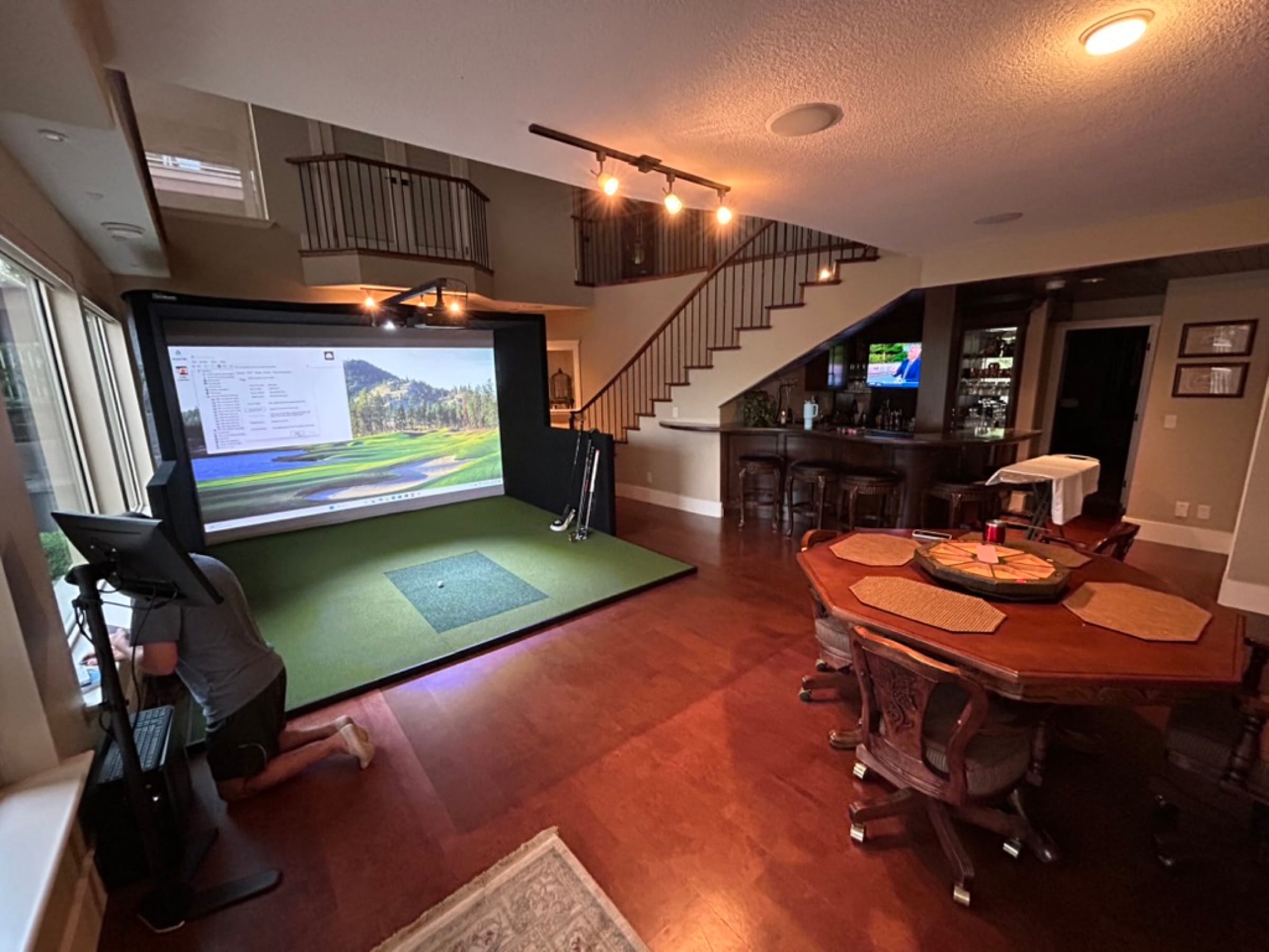 Player mid-swing in a two-storey loft install with live shot-analytics on screen